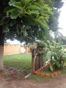 a wooden fence with a tree in a yard at Área de lazer camping in São Carlos +6 photos