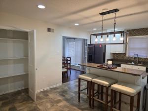 eine Küche mit einer Theke und Hockern darin in der Unterkunft Luxury Southern Mansion w/ Pool in Memphis