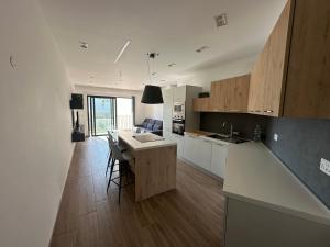 a kitchen with white cabinets and a island in a room at Brand New 2 Bedroom Apartment in Ħal Safi in Safi