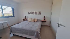 a bedroom with a bed and a desk and a window at Luminoso departamento en Mendoza in El Challao