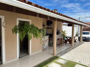 un patio di una casa con tavolo e sedie di CASA COM LAGO ORNAMENTAl a Santa Cruz Cabrália