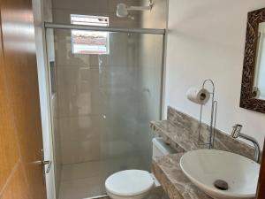 un bagno con doccia, WC e lavandino di CASA COM LAGO ORNAMENTAl a Santa Cruz Cabrália Altre 9 foto