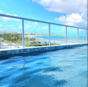 a swimming pool with a view of the ocean at Apartamento Beira Mar de João Pessoa PB in João Pessoa +3 photos