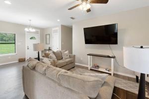 a living room with a couch and a flat screen tv at Spacious Country Living with Fishing Lake in Grand Bay