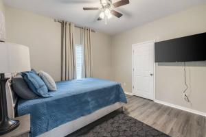 a bedroom with a blue bed and a ceiling fan at Spacious Country Living with Fishing Lake in Grand Bay