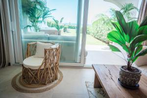 ein Wohnzimmer mit einem Sofa, einem Sessel und einer Pflanze in der Unterkunft Casa Elegancia - Beach Paradise in Marbella