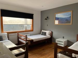 a small room with two beds and a window at Pristine Patagonia Hotel in Puerto Natales +37 photos