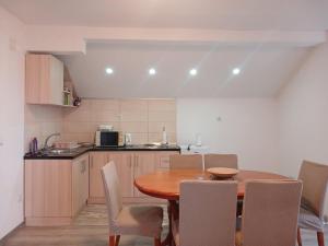 eine Küche mit einem Holztisch und Stühlen in einer Küche in der Unterkunft Apartman SELMA in Vogošća