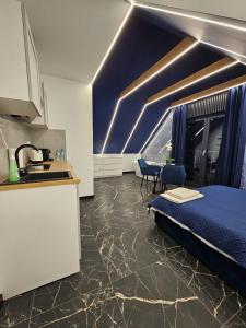 a room with a bed and a kitchen and a counter at Blue Love in Wrocław