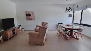 a living room with a tv and a table and chairs at Luminoso departamento en Mendoza in El Challao