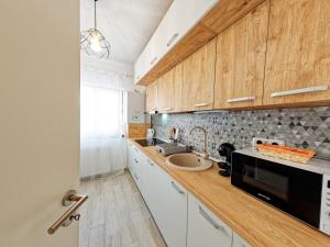 a kitchen with a sink and a microwave at FLH - Studio Escape Din Munti in Sînpetru