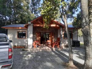 a house with a car parked in front of it at cabañas y tiny house los arrayanes in Pucón