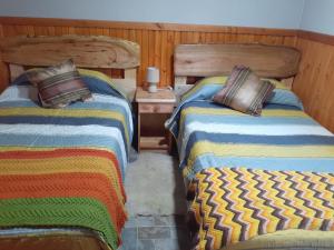 two beds sitting next to each other in a room at cabañas y tiny house los arrayanes in Pucón