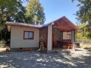 a small white house with a porch at cabañas y tiny house los arrayanes in Pucón +11 photos