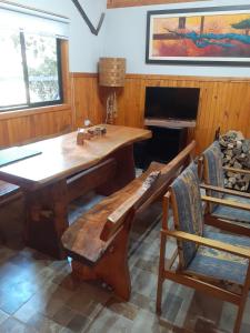 a dining room with a wooden table and chairs at cabañas y tiny house los arrayanes in Pucón