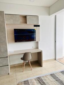 Cette chambre dispose d'un bureau, d'une télévision et d'une chaise. dans l'établissement Hermosa APARTASUITE EN CARTAGENA!!, à Carthagène des Indes