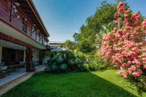 a garden with pink flowers next to a building at Ubatuba Ecologic Pousada in Ubatuba