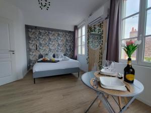 a bedroom with a bed and a table with a table sidx sidx sidx at Studio Kamelia in Saint-Aignan