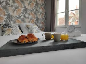 a tray with two croissants and two cups of orange juice at Studio Kamelia in Saint-Aignan