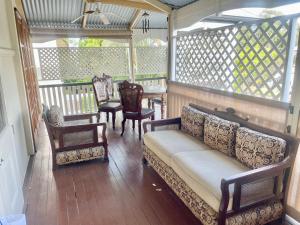 a porch with a couch and chairs and a table at Kent Street Retreat in Brisbane