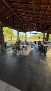 a group of chairs and tables in a pavilion at Sítio bom gosto in Tutóia