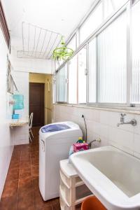 a bathroom with a washing machine and a sink at Cobertura com piscina privativa próxima à praia in Cabo Frio +34 photos