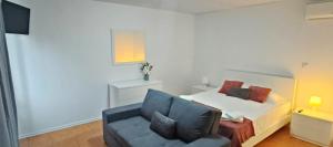 a bedroom with a bed and a blue couch at Faial Oceanfront Getaway AL in Horta