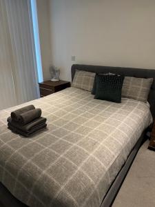 a bed with two pillows on top of it at Lovely 1Bed flat 10mins to Canary Wharf & parking in Woolwich