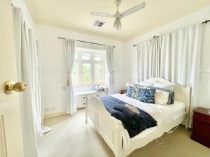 a bedroom with a white bed and a window at Kent Street Retreat in Brisbane