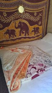 a bed with a pillow with tigers painted on it at LA PETITE MAISON DU LAC IRIKI in Foum Zguid