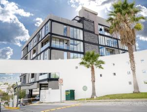 a building with palm trees in front of it at Departamento moderno en zona norte in Laurel de Lagunillas