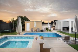 a swimming pool with white umbrellas in a backyard at villa Suhalj in Medulin