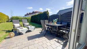 eine Terrasse mit Tisch und Stühlen in einem Hof in der Unterkunft Haus Eversand 2 in Cuxhaven