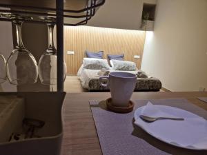 a table with a plate and a cup and a bed at La Vetere House in Catania