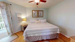 ein Schlafzimmer mit einem Bett und einem Deckenventilator in der Unterkunft 1505 Forrest in Folly Beach