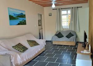 a living room with a couch and a bed and a window at Casa Costa Verde-Muriqui in Vila Muriqui