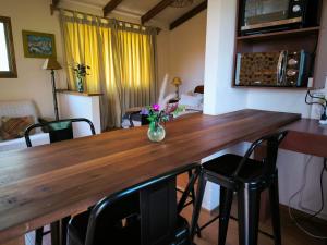 a dining room table with a vase of flowers on it at Cabaña Viñateros de Raiz a10 min de Chocalan in Melipilla