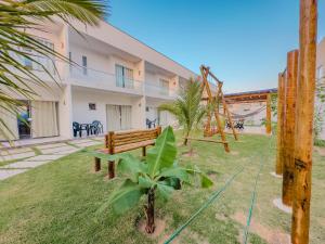 a park with a bench in front of a building at Apartamento 5 Duplex 2 Suites Perto Praia do Mutá in Santa Cruz Cabrália