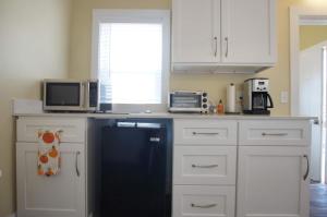a kitchen with white cabinets and a black dishwasher at Grand Harbor Apartments 209 Clinton Unit 2 in Grand Haven