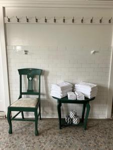 a room with a green table and a chair and towels at The Riverine Club in Wagga Wagga