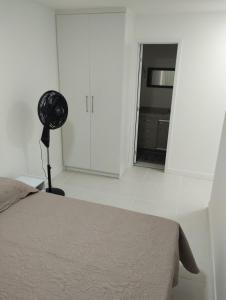 a bedroom with a bed and a room with a fan at Apartamento Carnaval Cabo Frio in Cabo Frio +23 photos