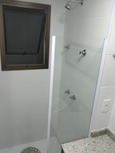 a bathroom with a shower with a television in it at Apartamento Carnaval Cabo Frio in Cabo Frio