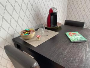 a table with a coffee maker and a bowl of candy at Chambre d'hôtes de l'Angeline in Bissey-sous-Cruchaud