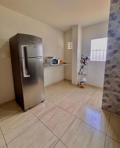 a kitchen with a stainless steel refrigerator in a room at 01 Apartamento Mandacaru in Caruaru
