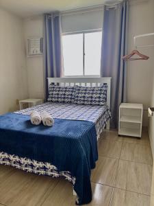 a bedroom with a bed with two slippers on it at 01 Apartamento Mandacaru in Caruaru