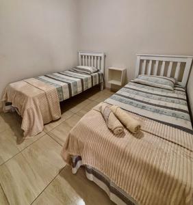 two beds sitting next to each other in a room at 01 Apartamento Mandacaru in Caruaru +3 photos