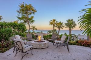 a group of chairs around a fire pit on the beach at Villa Las Brisas by Cabo Villas in San José del Cabo