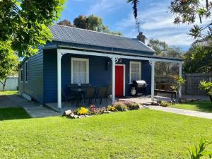 una casetta blu con una porta rossa di The Blue Cottage a Orbost