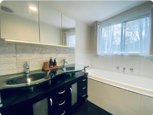 un bagno con due lavandini e una grande finestra di The Blue Cottage a Orbost