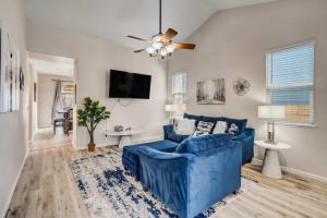 a blue couch in a living room with a ceiling fan at Pony Meadows Family Escape with BBQ & Workspace in Fountain +50 photos